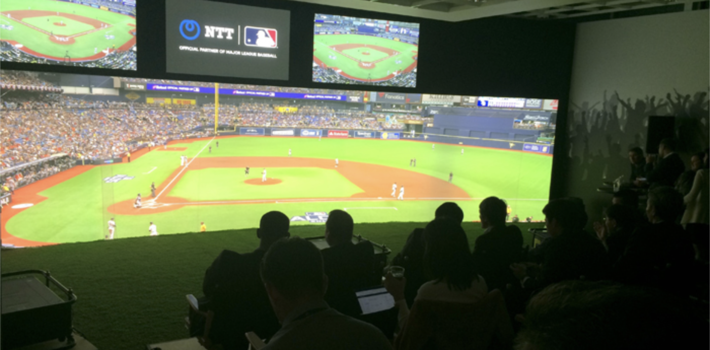 People watching a baseball game from a stadium tribune