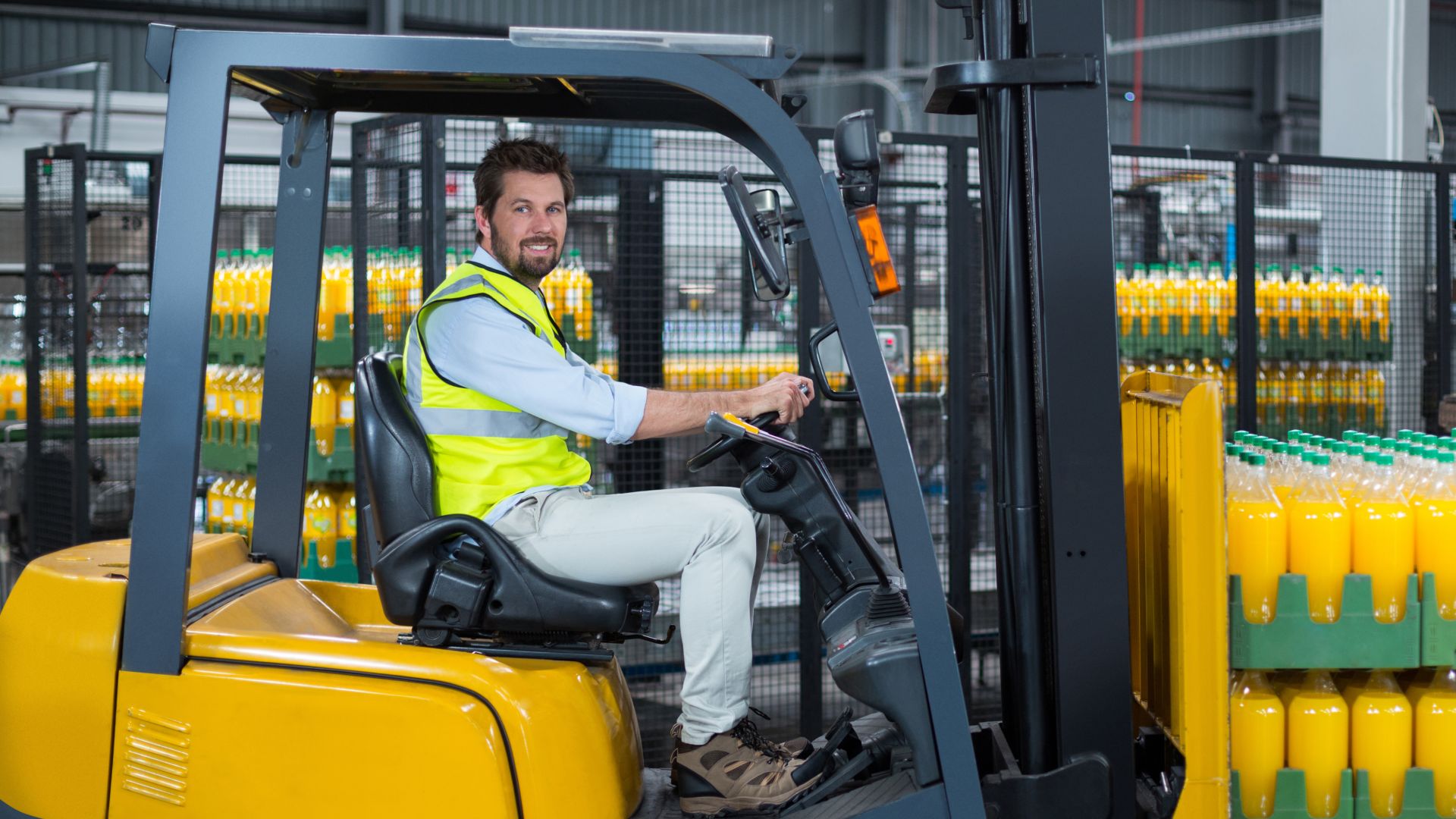 Man driving a fork lifter at a juice warehouse