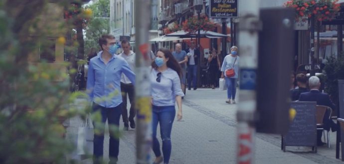 People walking in a street wearing preventative masks