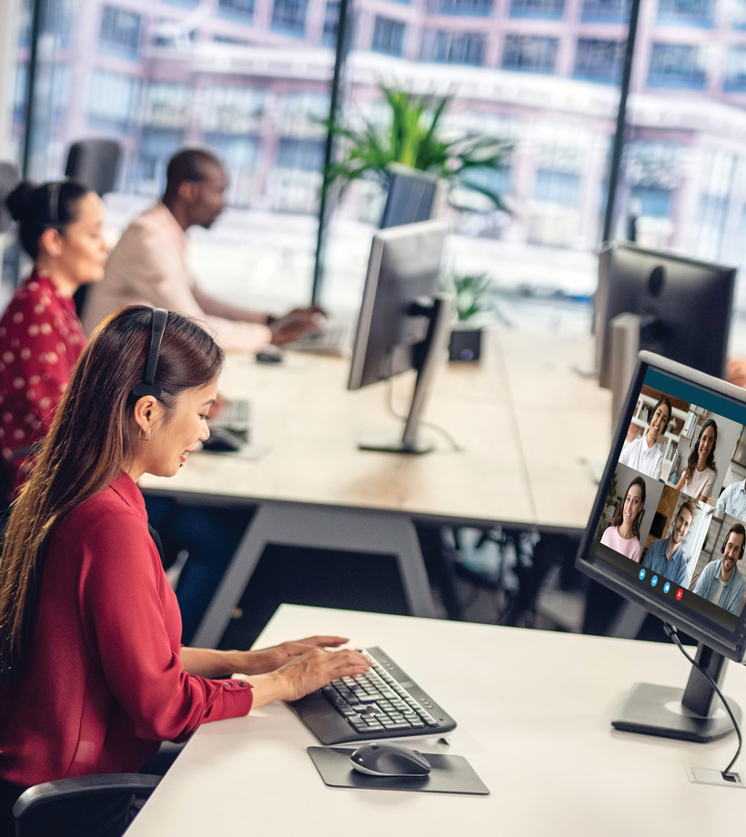 A team of people in an office area focusing on monitor screens