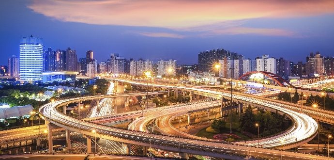 Motorway with light trails with city in the background