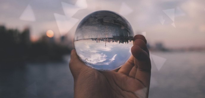 Hand holding out a glass ball