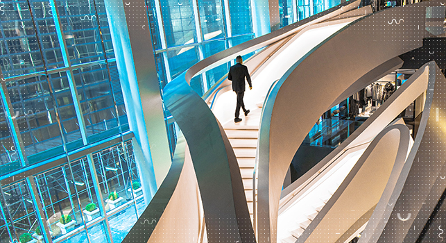 A person walking up steps in an office hall