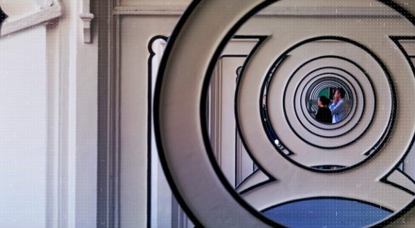 Two people's reflection in a circular mirror