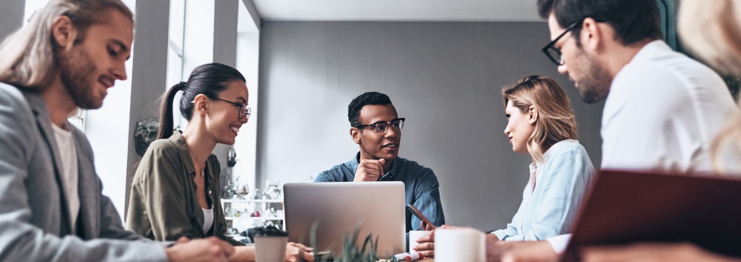 A group of people sitting around a meeting room table