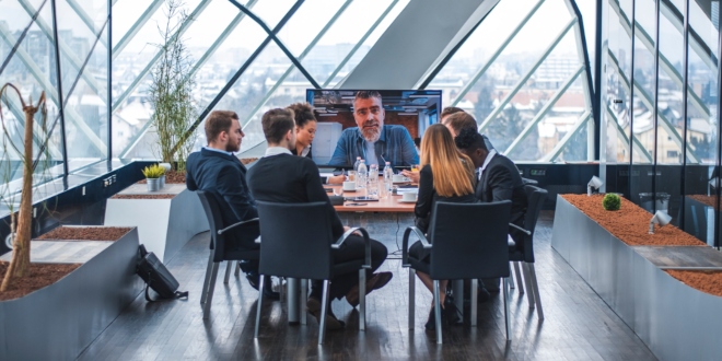 Colleagues sitting together around a meeting room table