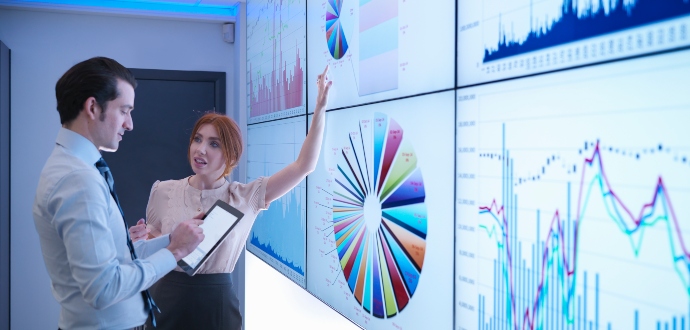 Business professional looking at screens with graphs