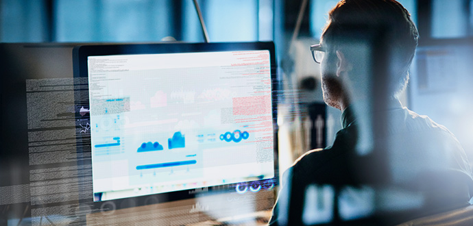 Man looking at graphs on a computer screen