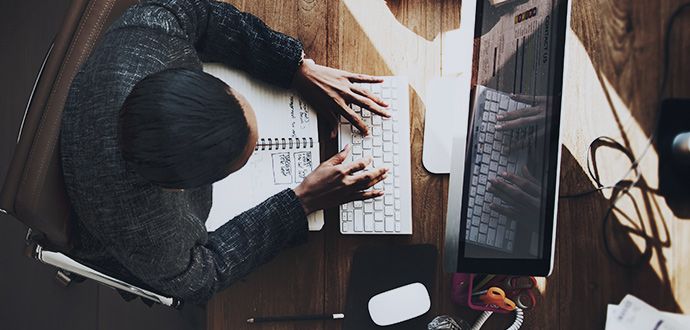 Person sitting at a desk working on a keyboard