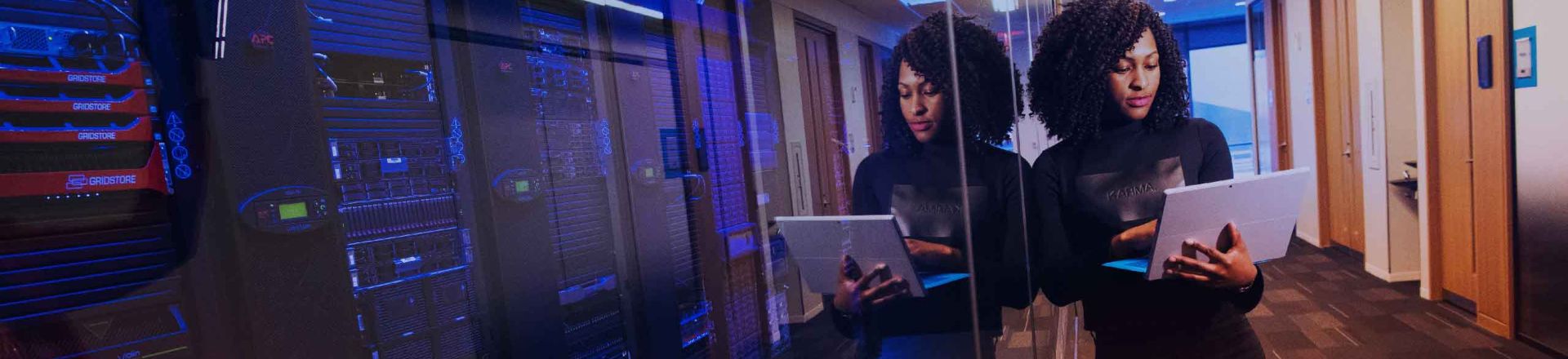 Reflection of a woman with laptop leaning against glass