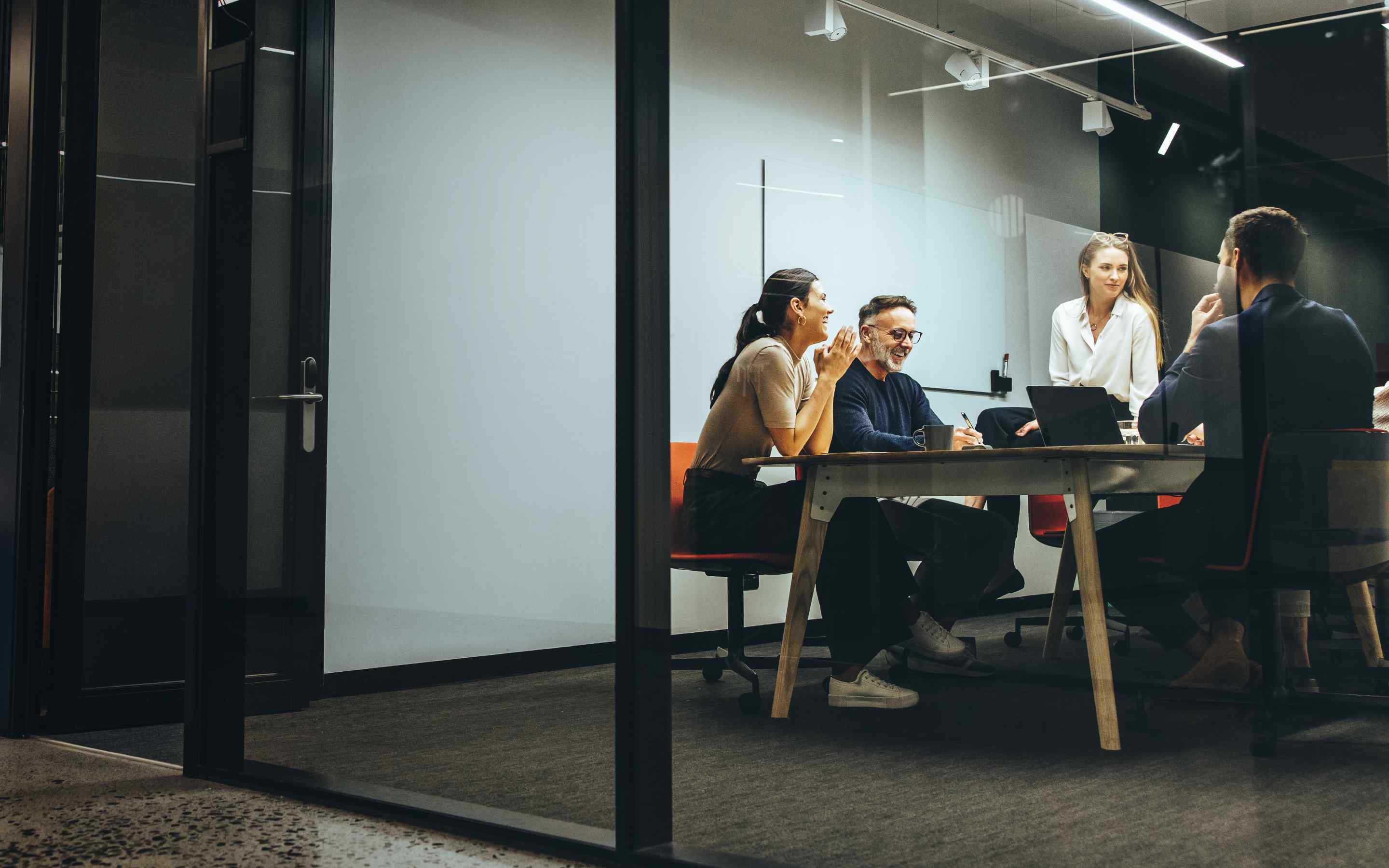 Workers leaning in to a meeting