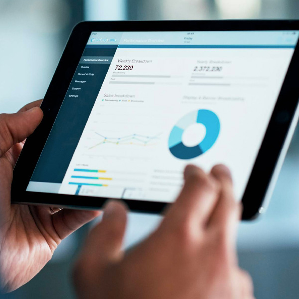 Office worker holding devices showing data charts and diagrams